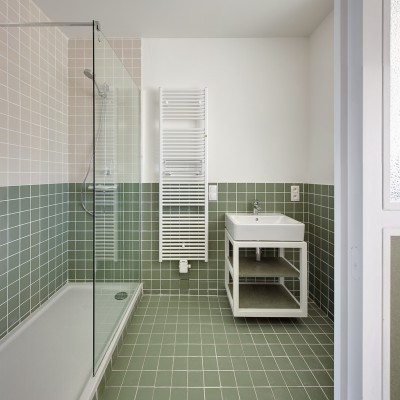 De badkamer is betegeld en voorzien van een inloopdouche, lavabo en handdoekverwarmer.
