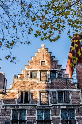 De achterzijde van het Brouwershuis in de straat Brouwersvliet heeft een trapgevel met rode baksteen, houten schrijnwerk en glas-in-loodramen.