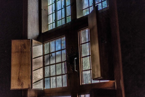 Houten schrijnwerk met glas-in-loodramen en houten luiken aan de binnenzijde van het Brouwershuis