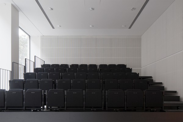 Zwarte zetels in het witte auditorium van het MoMu.